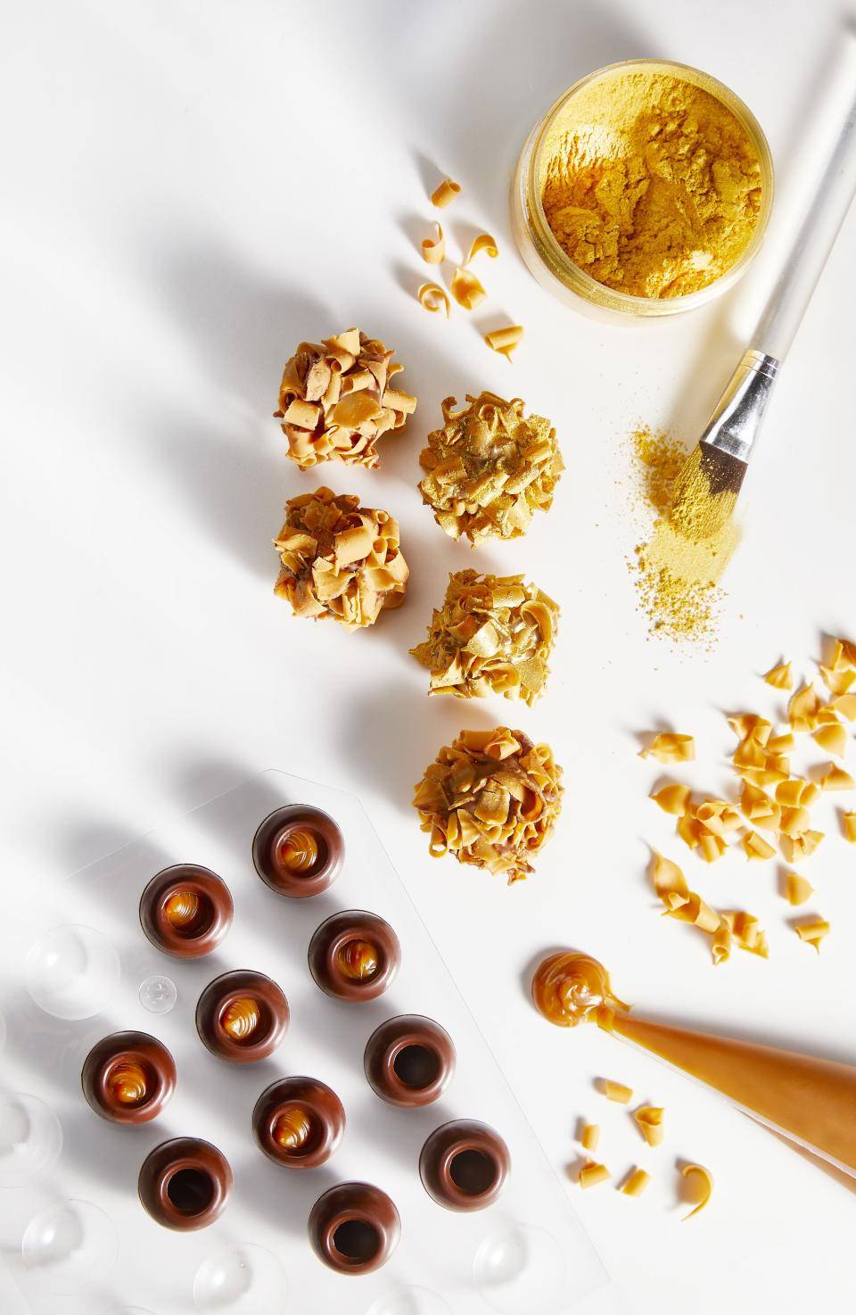 foto vista de cima de trufas de chocolate recheada de caramelo, brigadeiro com textura crocante e mangas de confeitar com caramelo