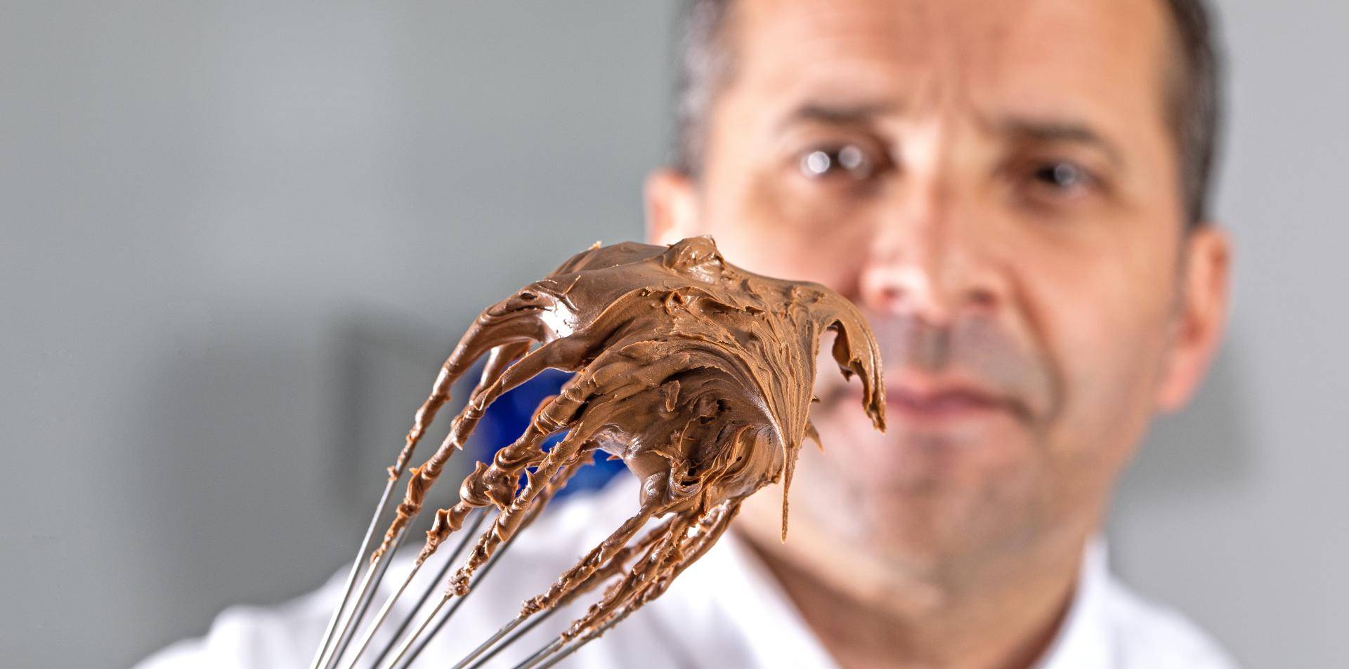 chef bertrand segurando um fuê com chocolate na ponta